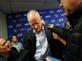 New York Mets general manger Sandy Alderson is assisted to his feet by reporters after collapsing during a news conference in New York on Nov. 4, 2015. (AP Photo/Seth Wenig)
