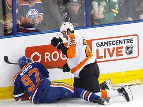Edmonton centre Connor McDavid (97) is talked to by Philadelphia defenceman Brandon Manning (23) after a hard hit into the boards during the second period of a NHL game between the Edmonton Oilers and the Philadelphia Flyers at Rexall Place in Edmonton, Alta. on Tuesday November 3, 2015. Ian Kucerak/Edmonton Sun/Postmedia Network