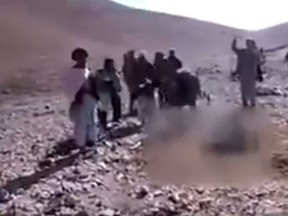 Suspected Taliban fighters stone 22-year-old Rokshana to death after she was accused of adultery, in this video that could not be independently verified. The woman was forced to stand in a deep hole in the ground during the Oct. 24 attack in a village in remote Ghor province of western Afghanistan. (YouTube/Screengrab)