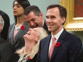 Minister of Environment and Climate Change Catherine McKenna, bottom middle, and Minister of Fisheries, Oceans and the Canadian Coast Guard Hunter Tootoo share a laugh during a cabinet photo following the swearing-in of the new Liberal cabinet during a ceremony at Rideau Hall in Ottawa on Wednesday, November 4, 2015. THE CANADIAN PRESS/Sean Kilpatrick