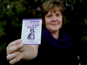 Emily Mountney-Lessard/The Intelligencer
Jennifer Loner, training and education coordinator at Three Oaks, holds a card that reads 'The courage of a woman alone is not enough.' The statement has been adopted for the Wrapped in Courage purple scarf campaign to support Women Abuse Prevention Month.