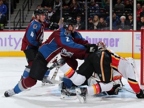 Nick Holden (No. 2) of the Colorado Avalanche puts a hit on Sam Bennett (No. 93) of the Calgary Flames as the puck flies over the goal at Pepsi Center on November 3, 2015 in Denver, Colorado. The Avalanche defeated the Flames 6-3. Photo by Doug Pensinger/Getty Images-AFP