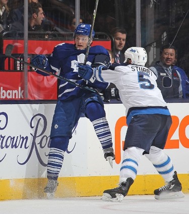 TORONTO, ON - NOVEMBER 4: Mark Stuart #5 of the Winnipeg Jets slams Byron Froese #56 of the Toronto Maple Leafs into the boards during an NHL game at the Air Canada Centre on November 4, 2015 in Toronto, Ontario, Canada.   Claus Andersen/Getty Images/AFP
== FOR NEWSPAPERS, INTERNET, TELCOS & TELEVISION USE ONLY ==