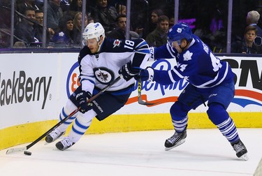 Morgan Rielly of the Toronto Maple Leafs checks Bryan Little of the Winnipeg Jets during NHL action at the Air Canada Centre in Toronto on Wednesday November 4, 2015. Dave Abel/Toronto Sun/Postmedia Network