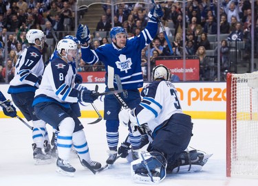 Toronto Maple Leafs' Leo Komarov, second from right, celebrates a goal in front of Winnipeg Jets' Adam Lowry, left to right, Jacob Trouba and goaltender Ondrej Pavelec during second period NHL hockey action, in Toronto, on Wednesday, Nov. 4, 2015. THE CANADIAN PRESS/Darren Calabrese
