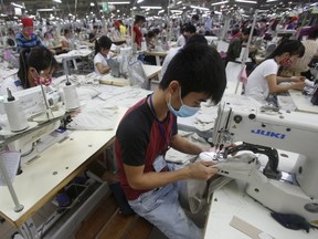 Labourers work at a garment factory in Bac Giang province, near Hanoi October 21, 2015. Vietnam's textiles and footwear would gain strongly from the TPP, after exports of $31 billion last year for brands such as Nike, Adidas, H&M, Gap, Zara, Armani and Lacoste. (REUTERS/Kham)