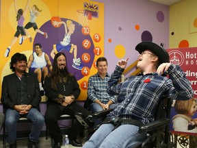 Pediatric patient Janessa Gerhardt, 16, shares a laugh with members of The Tragically Hip, from left, Paul Langlois, Rob Baker and Gord Sinclair at the unveiling of three pediatric areas renovated by the Smilezone Foundation at Hotel Dieu Hospital on Thursday. (Elliot Ferguson/The Whig-Standard)