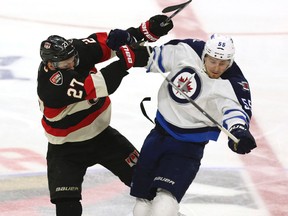 Winnipeg Jets' Mark Scheifele (55) collides with Ottawa Senators' Curtis Lazar during the second period of an NHL hockey game Thursday, Nov. 5, 2015, in Ottawa, Ontario. (Fred Chartrand/The Canadian Press via AP)