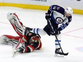 Ottawa Senators' goaltender Craig Anderson (41) comes out of his net to make a stick save on a shoot-out attempt by Winnipeg Jets' Andrew Ladd (16) during overtime. The Senators beat the Jets 3-2, in Ottawa, on Thursday, Nov. 5, 2015. THE CANADIAN PRESS/Fred Chartrand