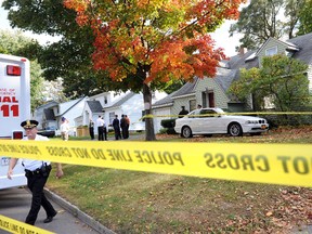 In this Oct. 8, 2014, file photo, authorities prepare to enter the scene of a quadruple homicide in Guilderland, N.Y., where Jin Chen, his wife and their two children were found fatally stabbed. Investigators since then have worked despite language barriers, cultural differences and the logistical challenge of a multiple murder case with connections running through Manhattan’s Chinatown. (Cindy Schultz/The Albany Times Union via AP)