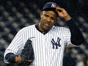 In this Oct. 1, 2015, file photo, New York Yankees starting pitcher CC Sabathia struggles with his cap in the rain during the first inning of a baseball game against the Boston Red Sox in New York. (AP Photo/Kathy Willens, File)