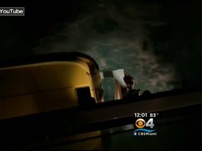 A video posted on YouTube shows a man who jumped onto a lifeboat on the side of a cruise ship and clung to the edge of the tiny vessel for more than minute before he plunged into the ocean below. (miami.cbslocal.com screengrab)