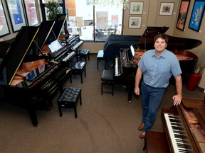 Darryl Fabiani, owner of D & S Pianos in Hyde Park, shows off the many piano options available. (MORRIS LAMONT, The London Free Press)