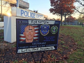 In this photo Wednesday, Nov. 4, 2015, a sign honouring Lt. Charles Joseph Gliniewicz is defaced outside Fox Lake Police Department in Fox Lake, Ill. Lake County officials confirmed Wednesday that Gliniewicz, 52, died Sept. 1 of a self-inflicted gunshot wound. Officials said Gliniewicz carefully staged his death to make it look like he was killed in the line of duty and had been stealing for years from a youth program he oversaw. (Lauren Zumbach/Chicago Tribune via AP)