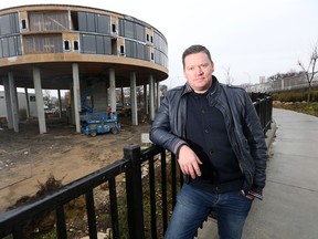 Mark Penner, president of Green Seed Development Corporation, poses with his futuristic looking condo project at 540 Waterfront.