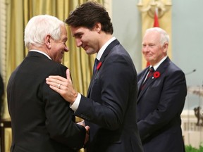 Canada's new Immigration, Citizenship and Refugees Minister John McCallum (L) is congratulated by Prime Minister Justin Trudeau, as Governor General David Johnston looks on, during a swearing-in ceremony at Rideau Hall in Ottawa November 4, 2015. REUTERS/Chris Wattie