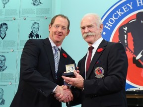 Lanny McDonald, Chairman of the Hockey Hall of Fame (right), presents Phil Housley with his Hall of Fame ring Friday.