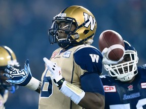 Winnipeg Blue Bombers' Dominique Davis, left, winds up for an incomplete pass as Toronto Argonauts' Martin Wright applies pressure during first half CFL action, in Toronto, on Friday, Nov. 6, 2015. THE CANADIAN PRESS/Frank Gunn