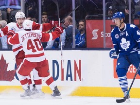 Detroit Red Wings' defender Jakub Kindl celebrates his overtime game-winning goal with teammate Henrik Zetterberg as Toronto Maple Leafs' forward Tyler Bozak, right, looks on during NHL hockey action, in Toronto, on Friday, Nov. 6, 2015. (THE CANADIAN PRESS/Nathan Denette)