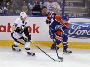 Edmonton Oilers' Taylor Hall (4) is chased by  Pittsburgh Penguins'  Chris Kunitz (14) during second period NHL action at Rexall Place in Edmonton, Alberta on November 6, 2015.  Perry Mah/Edmonton Sun/Postmedia Network