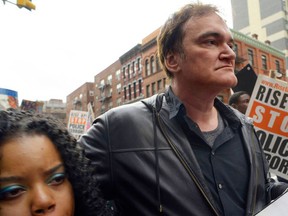 FILE - In this Oct. 24, 2015 file photo, director Quentin Tarantino, center, participates in a rally to protest against police brutality in New York. Calls by police groups to boycott Quentin Tarantino’s “The Hateful Eight” are putting pressure on one of December’s most anticipated releases and inserting one of Hollywood’s top directors into a pitched cultural battle.In recent days, a growing number of police groups have called for the boycott of the upcoming Weinstein Co. release.  (AP Photo/Patrick Sison, File)