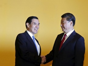 Chinese President Xi Jinping shakes hands with Taiwan's President Ma Ying-jeou (L) during a summit in Singapore November 7, 2015. Leaders of political rivals China and Taiwan met on Saturday for the first time in more than 60 years for talks that come amid rising anti-Beijing sentiment on the self-ruled democratic island and weeks ahead of elections there. (REUTERS/Edgar Su)