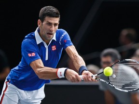 Novak Djokovic returns the ball to Stanilas Wawrinka during their semifinal match of the BNP Masters at the Paris Bercy Arena, in Paris Saturday, Nov. 7, 2015. (AP Photo/Michel Euler)