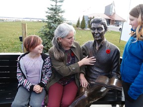 Lesley Bonisteel, muses over the bronze statue of her late father, Roy Bonisteel, with his great-granddaughters, Abbigail Bonisteel-Lajoie, 7, and Melody  Bonisteel-Lajoie, age 10.