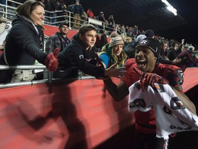 Ottawa Redblacks' wide receiver Maurice Price celebrates with fans after the Redblacks beat the Hamilton Tiger-Cats, in Ottawa, on Saturday Nov. 7, 2015. THE CANADIAN PRESS/Adrian Wyld