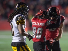 Hamilton Tiger-Cats' defensive back Rico Murray walks past Ottawa Redblacks' wide receiver Chris Williams, centre, and teammate Brad Sinopoli celebrating a touchdown during second half CFL action, in Ottawa, on Saturday, Nov. 7, 2015. THE CANADIAN PRESS/Adrian Wyld