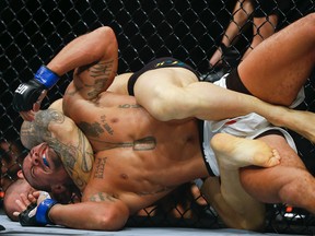 Gleison Tibau, of Brazil, back, chokes Abel Trujillo, of the United States, during their UFC lightweight mixed martial arts bout in Sao Paulo, Brazil, Sunday, Nov. 8, 2015. (AP/Andre Penner)