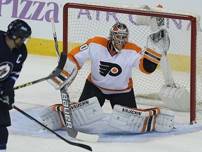 Flyers goaltender Michal Neuvirth makes a glove save as Jets forward Andrew Ladd misses the deflection attempt on Saturday. (Kevin King/Winnipeg Sun)