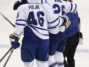 Leafs’ Daniel Winnik is helped off the ice after being injured during Saturday night’s game against the Capitals in Washington. (USA TODAY SPORTS/PHOTO)
