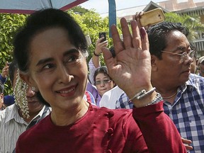 Myanmar pro-democracy leader Aung San Suu Kyi waves at supporters as she visits polling stations at her constituency Kawhmu township November 8, 2015. Voting began on Sunday in Myanmar's first free nationwide election in 25 years, the Southeast Asian nation's biggest stride yet in a journey to democracy from dictatorship.  (REUTERS/Soe Zeya Tun)