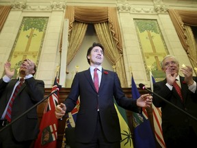 Prime Minister Justin Trudeau (C) receives a standing ovation during a Liberal caucus meeting on Parliament Hill in Ottawa November 5, 2015. (REUTERS/Chris Wattie)