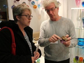 Wellington hot glass artist Mark Armstrong shows some of his work to Connie Howell of Brighton at The Makerís Hand artisan show in Picton on the weekend.