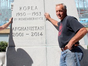 The decades-old typo on the Chatham cenotaph - an extra letter e in the word remembrance - is shown in this photograph from last month, when Michael Markham, left, and Phil Bertolini showed off the addition to the monument of lines saluting Canada's role in the Afghanistan War.  (Postmedia Network file photo)