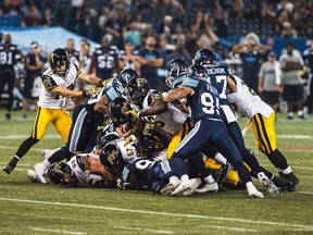 Hamilton Tiger-Cats push for a first down against the Toronto Argonauts during second half CFL action in Toronto on Friday, September 11, 2015. Hamilton won 35-27. The THE CANADIAN PRESS/Aaron Vincent Elkaim