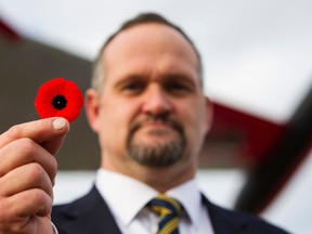 Royal Canadian Legion Branch #108 President Sean Cuppens poses for a photo with a poppy outside the branch in Leduc, Alta., on Saturday October 31, 2015. Ian Kucerak/Edmonton Sun/Postmedia Network