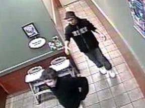 Cops are looking to identify two men suspected of lifting a poppy box from a coffee shop at 1024 Bloor St. W. (Toronto Police handout)