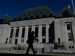 A pedestrian walks past the Supreme Court of Canada in Ottawa on Thursday, July 23, 2015. THE CANADIAN PRESS/Sean Kilpatrick