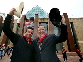Tim Shipton, left, vice-president of communications with the Edmonton Oilers, and Tim Reid, northlands president and CEO, tip their hats as they take part in a special Canadian Finals Rodeo kickoff event downtown on Monday. (Perry Mah, Edmonton Sun)