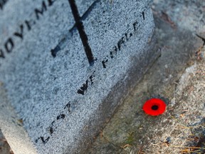 A poppy is seen on a grave stone during No Stone Left Alone at Beechmount Cemetary in Edmonton, Alta., on Tuesday, November 10, 2015. This year marks the 5th annual commemoration ceremonies for the No Stone Left Alone Memorial Foundation. School children from across Canada lay poppies on veterans graves ahead of Remembrance Day. Ian Kucerak/Edmonton Sun/Postmedia Network