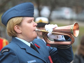 Capt. Kelly Dixon plays Last Post on her bugle in Cataraqui Cemetery in Kingston, Ont. on Tuesday, Nov. 10, 2015 during a pre-Remembrance Day ceremony in the cemetery's military section. Michael Lea/The Whig-Standard/Postmedia Network