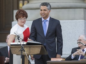 Irfan Sabir, Alberta's Human Services Minister and member of the New Democratic Party (NDP), signs as a member of the executive council during the official swearing-in ceremony in Edmonton, Alberta, Canada May 24, 2015. REUTERS/Topher Seguin