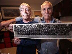 Doug (left), and Marcel Dutiaume are cousins; their fathers, who were identical twins, served in the Royal Winnipeg Rifles during the Second World War.  Their fathers served along with three of their four other siblings. Doug and Marcel are displaying a photo of B Company Royal Winnipeg Rifles taken in England in 1943.