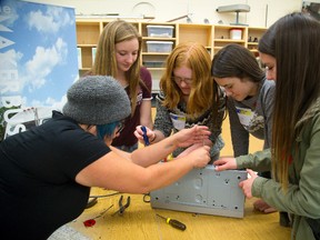 Lola Wong, left, of MakerBus, helps ninth-graders Laura Fritz, Maya Lyon-Brown, Emily Finlay and Lauren Jackson, all 14, remove a stripped screw from a recycled electronic device during Maker Day at London?s Montcalm secondary school Tuesday. (MIKE HENSEN, The London Free Press)