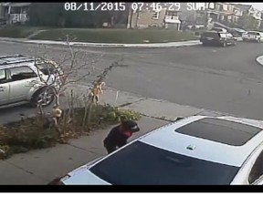 A woman appears to be vandalizing a car in this screengrab from surveillance video released by cops.