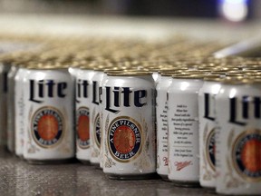 In this March 11, 2015 photo, newly-filled and sealed cans of Miller Lite beer move along on a conveyor belt, at the MillerCoors Brewery, in Golden, Colo. Molson Coors will nearly double its size once it completes a US$12-billion purchase that secures full ownership of its U.S. beer business and gains worldwide control of the Miller brand name. THE CANADIAN PRESS/AP Photo/Brennan Linsley