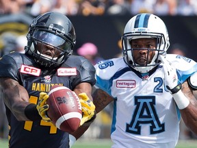 Hamilton Tiger-Cats wide receiver Terrell Sinkfield Jr. (14) makes a fingertip catch while watched by Toronto Argonauts defensive back Branden Smith (26) during the first-half of CFL football action in Hamilton on Monday, September 7, 2015. THE CANADIAN PRESS/Peter Power
